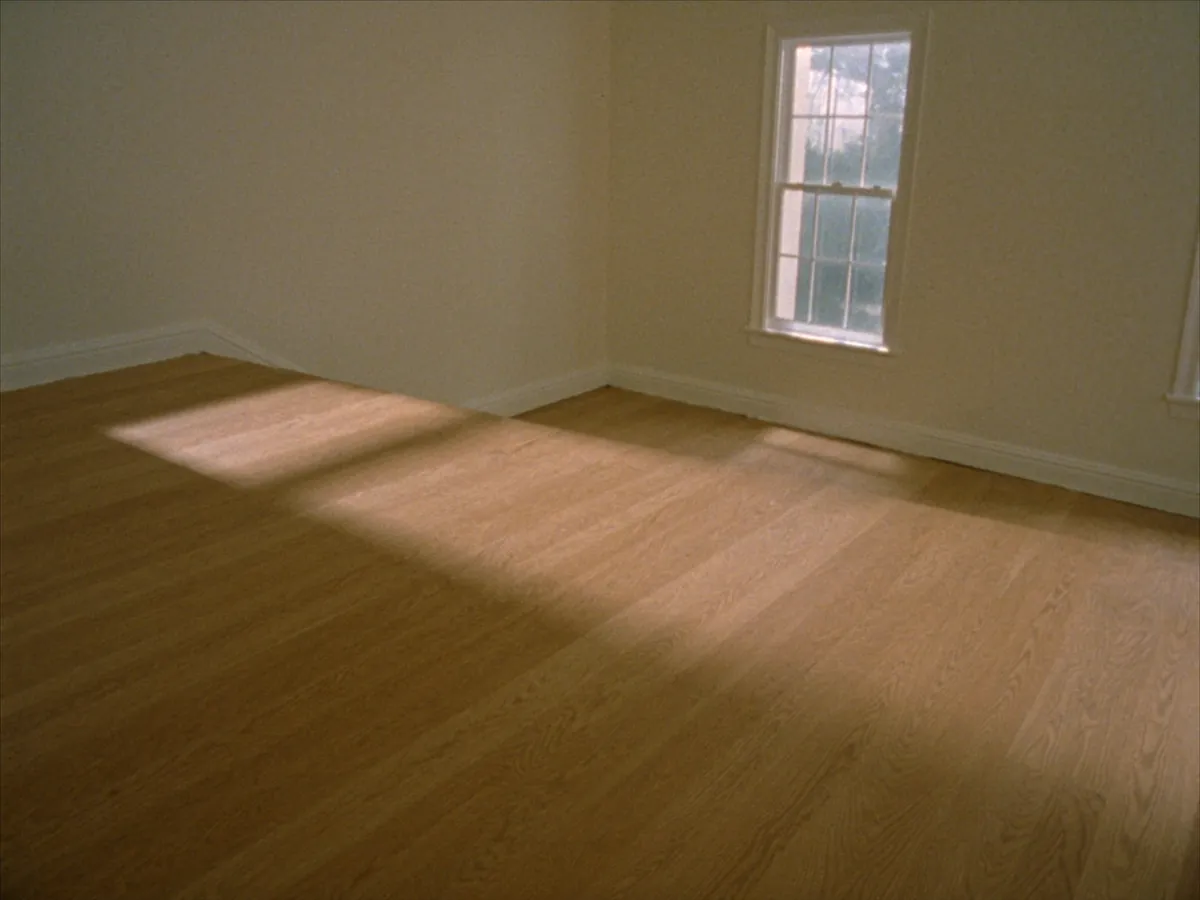 Solid white oak hardwood flooring across an empty upstairs room with morning light falling from a sash window